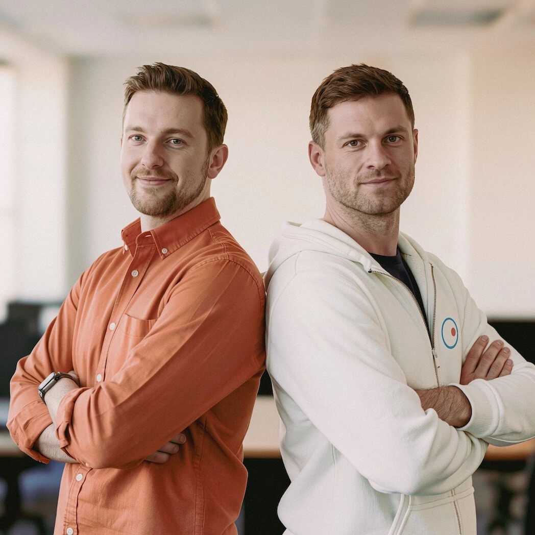 Two IT professionals pose side by side, expressing trust and collaboration in the distribution of solutions for remote access and IT management, backup and cybersecurity.